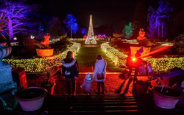Guests walking through illuminated gardens at Warwick Castle Light Trail.