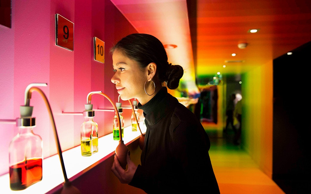 Visitor exploring scent bottles at Bols Cocktail Experience, Amsterdam.