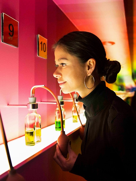 Visitor exploring scent bottles at Bols Cocktail Experience, Amsterdam.