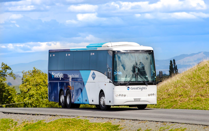 Tour bus traveling from Auckland to Hobbiton Movie Set, Waitomo Caves, Te Puia.