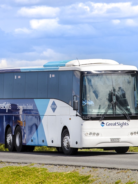 Tour bus traveling from Auckland to Hobbiton Movie Set, Waitomo Caves, Te Puia.
