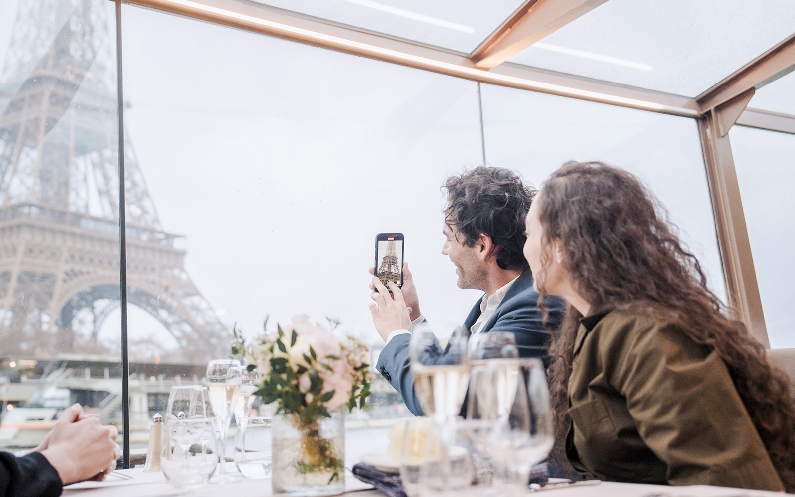 Couple enjoying Seine River lunch cruise with Eiffel Tower view.
