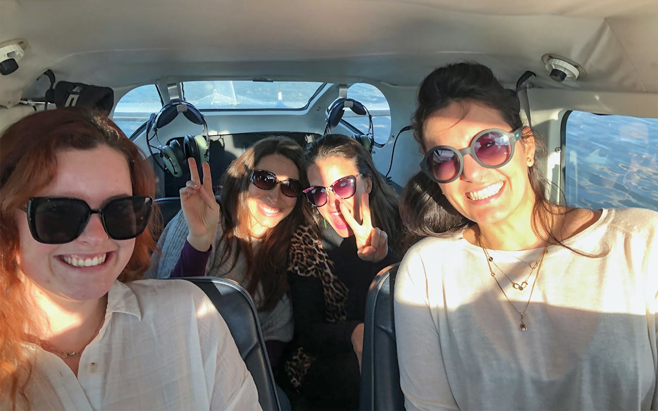 Group of people smiling inside a floatplane during White Island and Mount Tarawera tour.