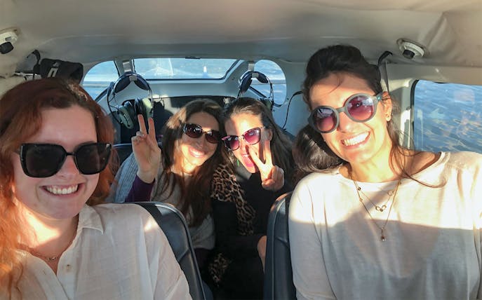 Group of people smiling inside a floatplane during White Island and Mount Tarawera tour.