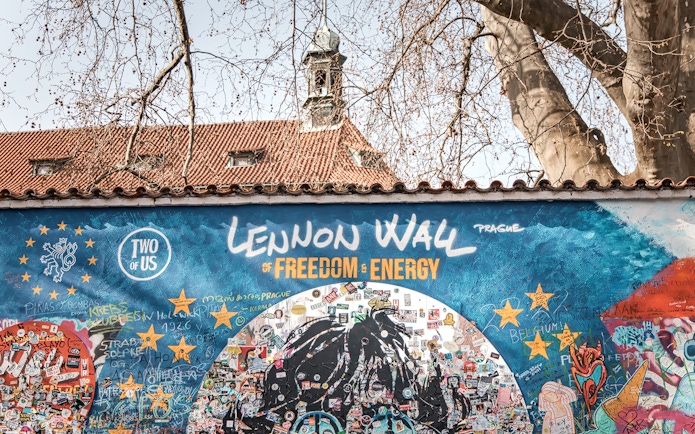Lennon Wall in Prague with colorful graffiti and messages, part of the Prague Old Town tour.