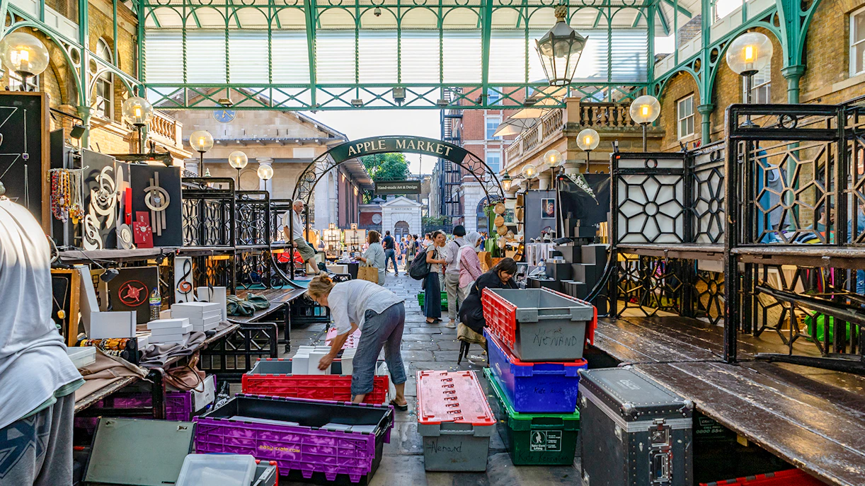 Covent Garden Apple Market in London with vendors setting up stalls.
