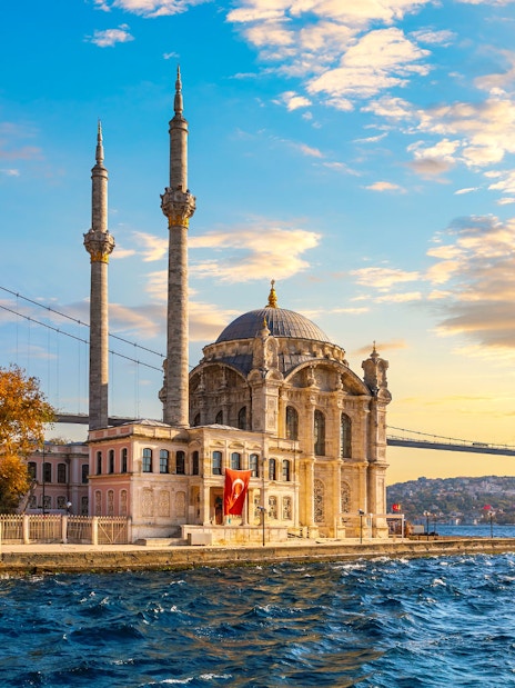 Ortaköy Mosque and Bosphorus Bridge at sunset during a yacht cruise in Istanbul.