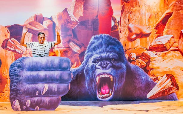 Man posing with 3D gorilla art at Trick Eye Museum, Singapore.