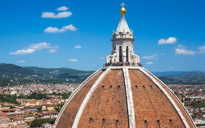 Brunelleschi's dome atop Florence Cathedral with cityscape in the background.