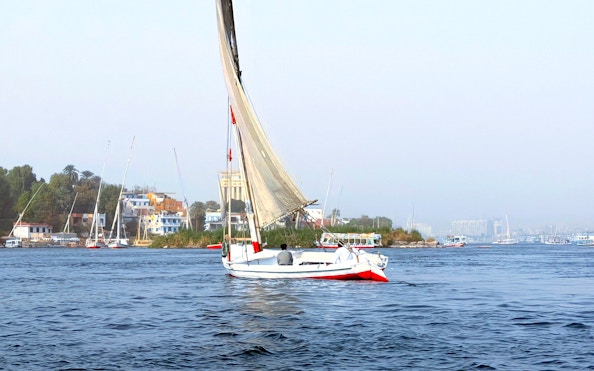 Felucca sailing on the Nile River with Cairo skyline in the background.