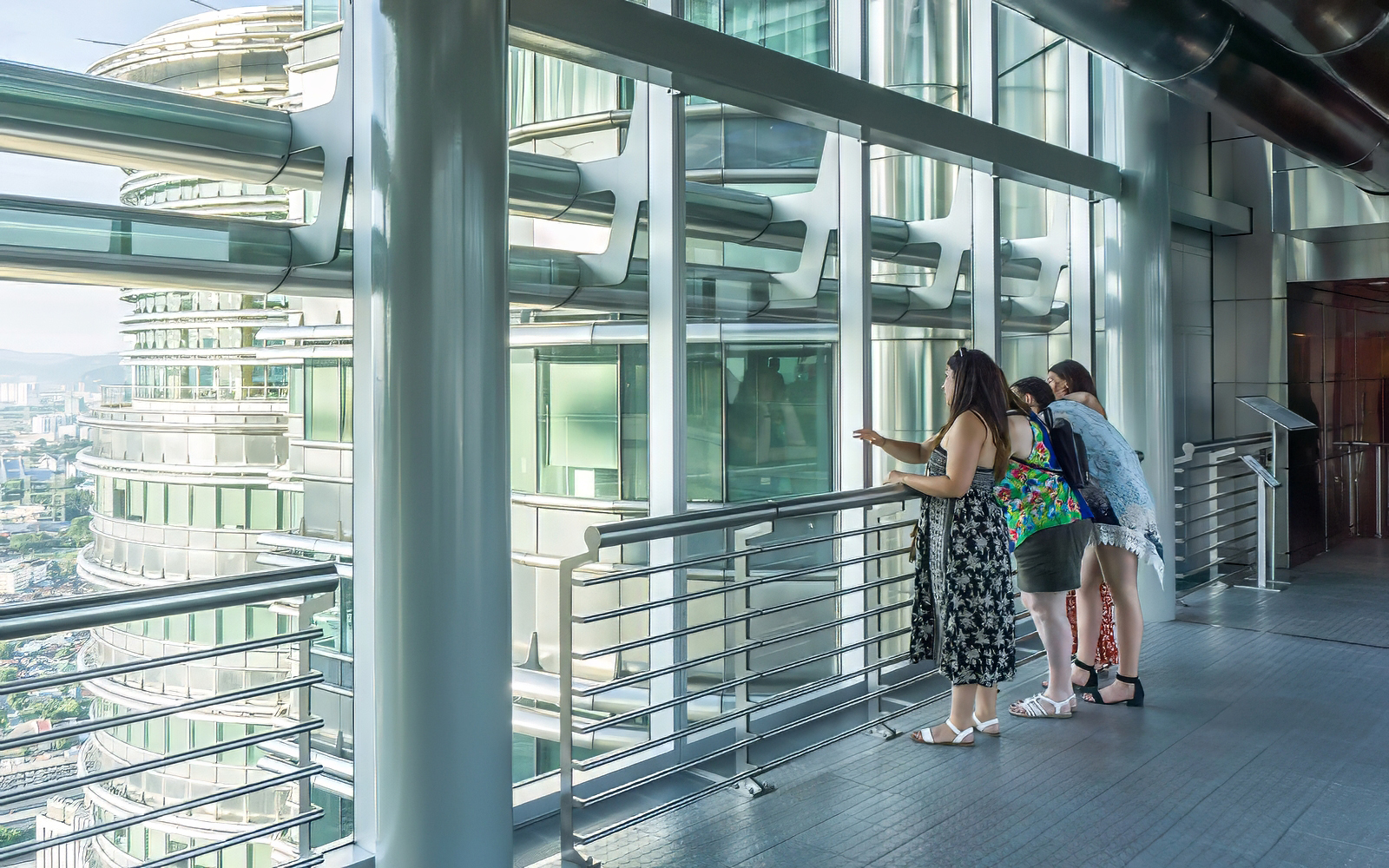 Visitors observing the Petronas Twin Towers from the sky bridge in Kuala Lumpur.