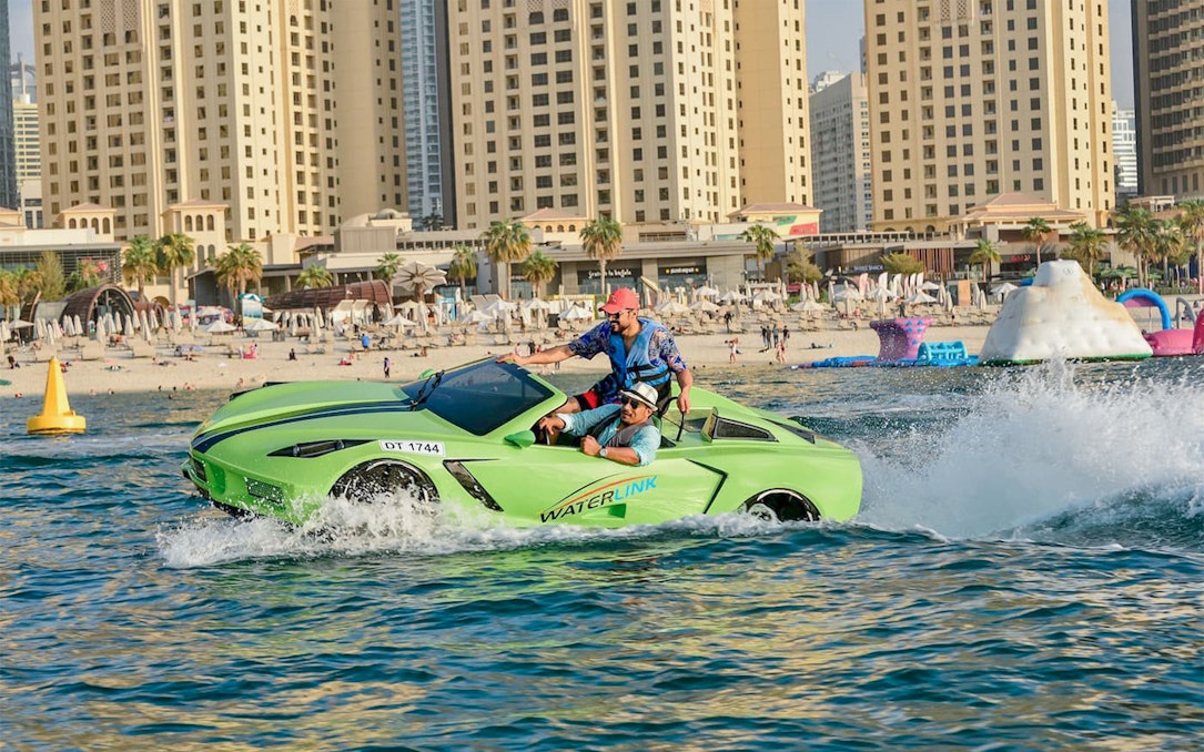Jet car on water near Dubai beach with city skyline in background.
