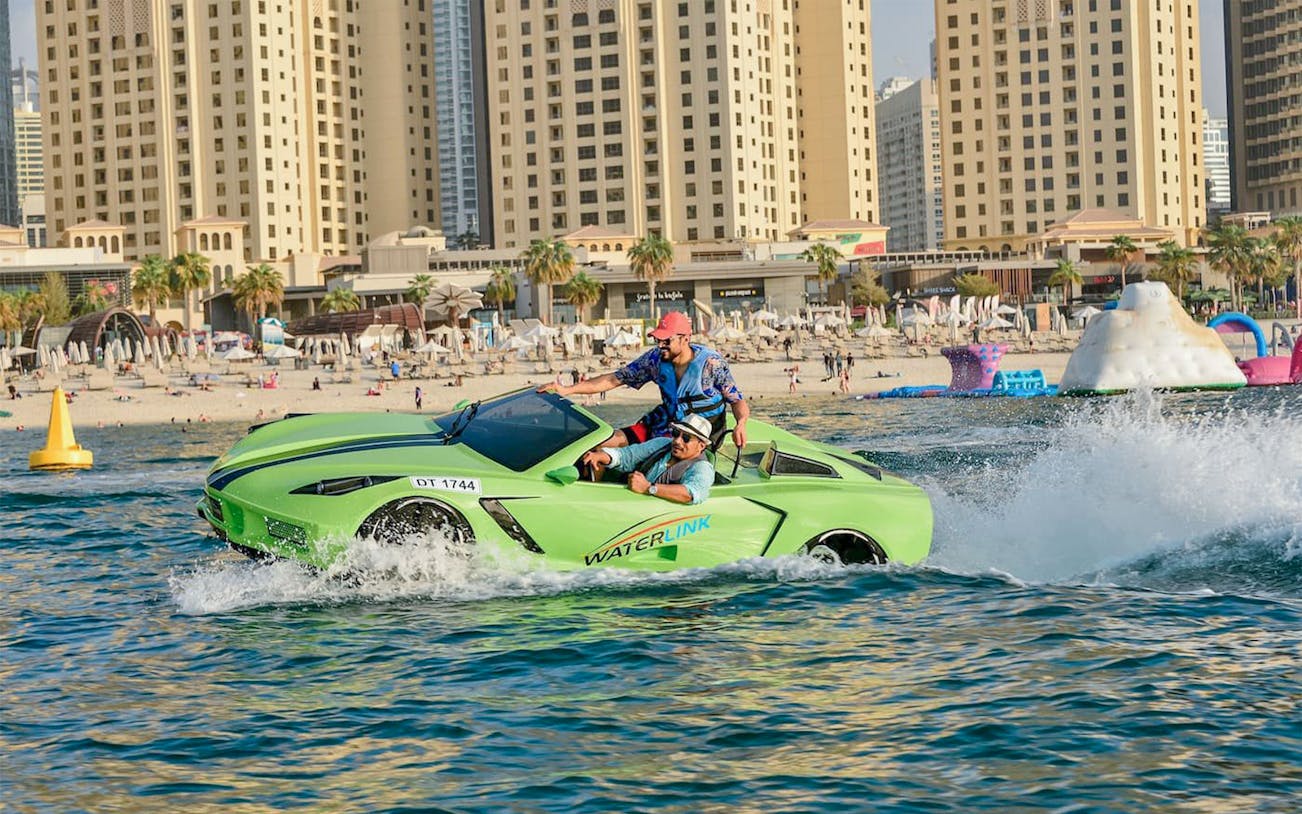 Jet car on water near Dubai beach with city skyline in background.