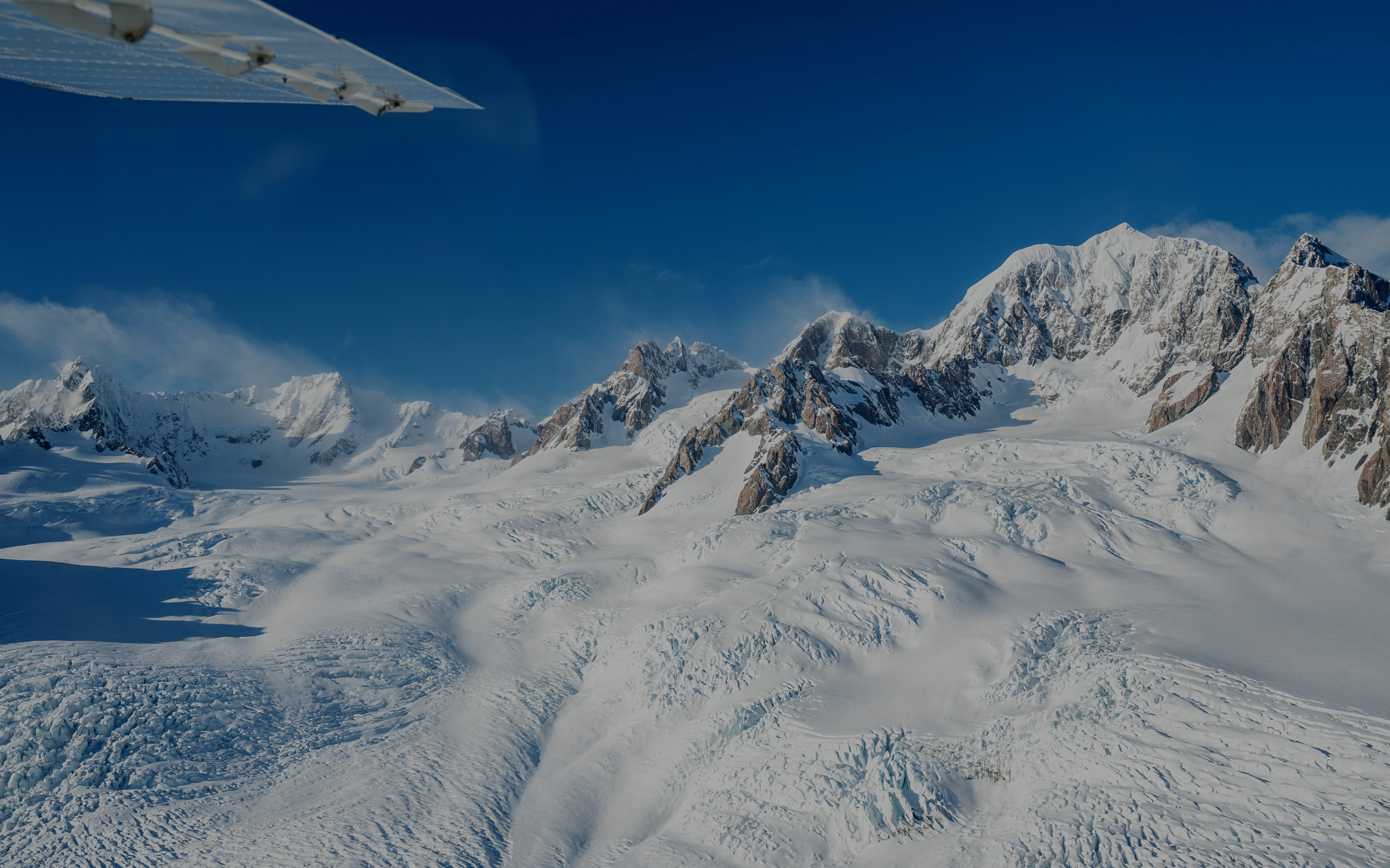 Scenic flight view of glaciers and mountains in South Island, New Zealand.