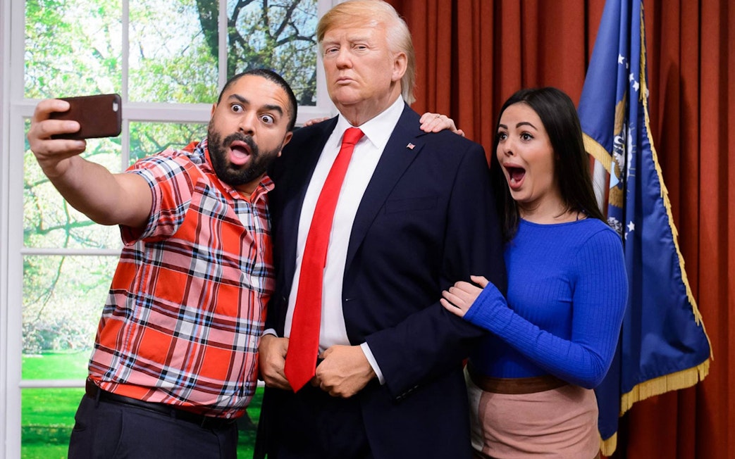 Visitors taking a selfie with a wax figure at Madame Tussauds Hong Kong.