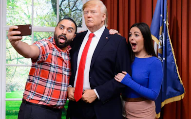 Visitors taking a selfie with a wax figure at Madame Tussauds Hong Kong.