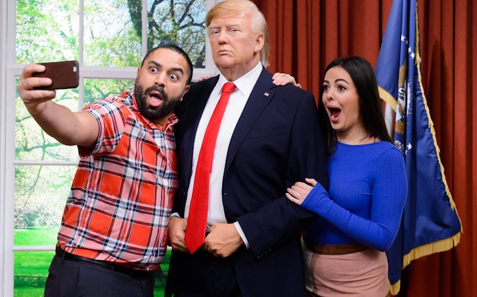 Visitors taking a selfie with a wax figure at Madame Tussauds Hong Kong.