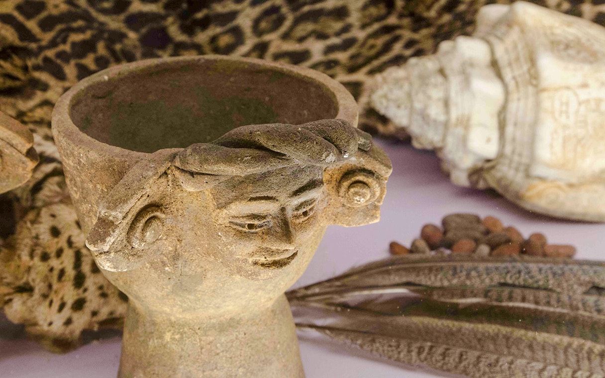 Ancient artifact with carved face in Chocolate Museum Paris exhibit.