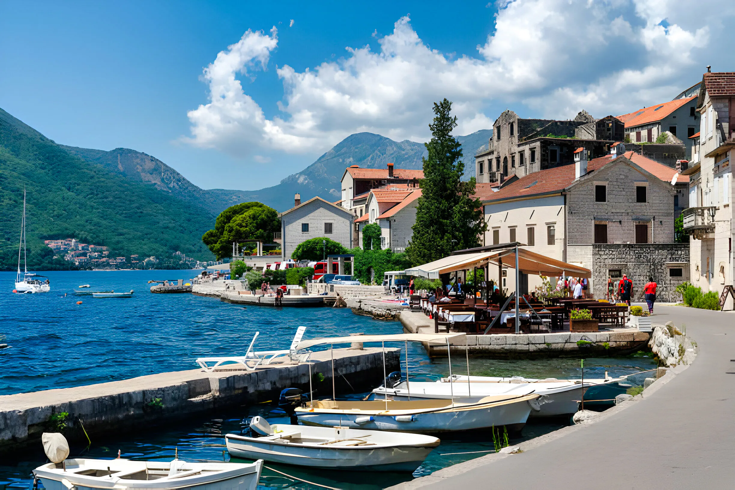 Boats docked along the waterfront in Perast with mountains in the background, Kotor.