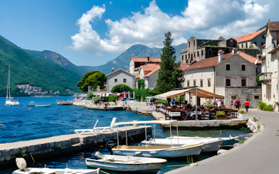 Boats docked along the waterfront in Perast with mountains in the background, Kotor.