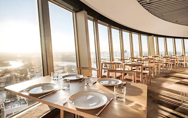 Dining tables set at SkyFeast, Sydney Tower, with panoramic city views.