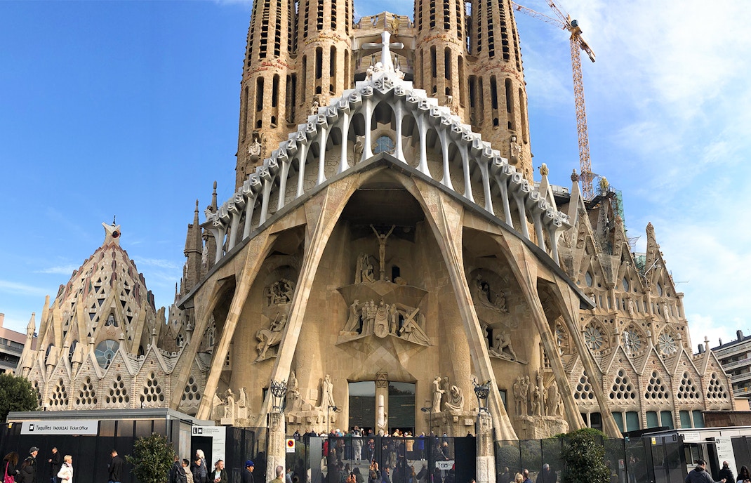 Sagrada Familia exterior with tourists entering through fast-track guided access in Barcelona.
