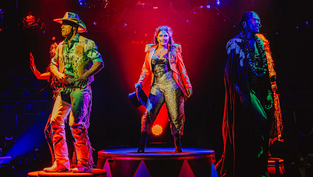 Performers on stage during Come Alive Westend show, featuring vibrant costumes and dramatic lighting.