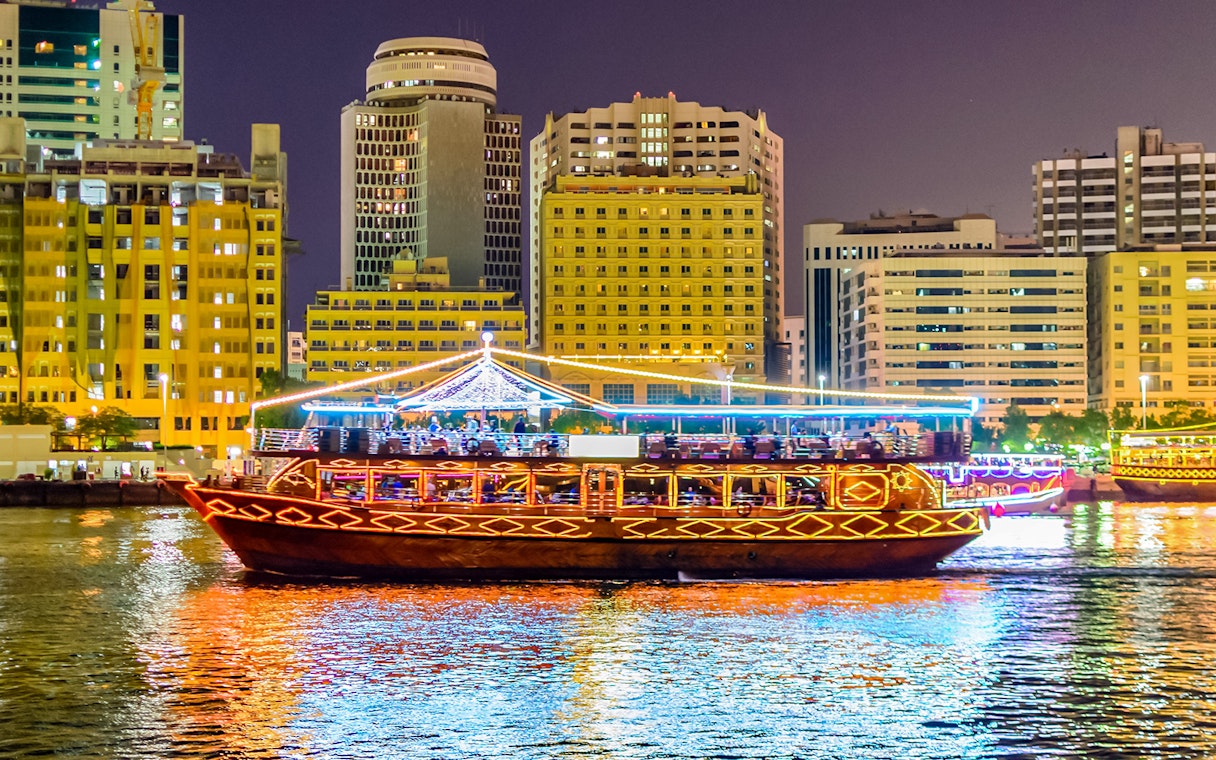 Dhow boat cruising Dubai Marina with city skyline, part of Big Bus Dubai tour.
