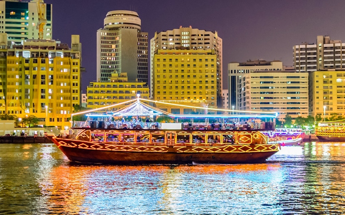 Dhow boat cruising Dubai Marina with city skyline, part of Big Bus Dubai tour.