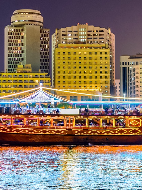 Dhow boat cruising Dubai Marina with city skyline, part of Big Bus Dubai tour.