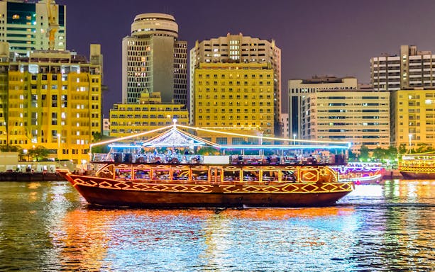 Dhow boat cruising Dubai Marina with city skyline, part of Big Bus Dubai tour.