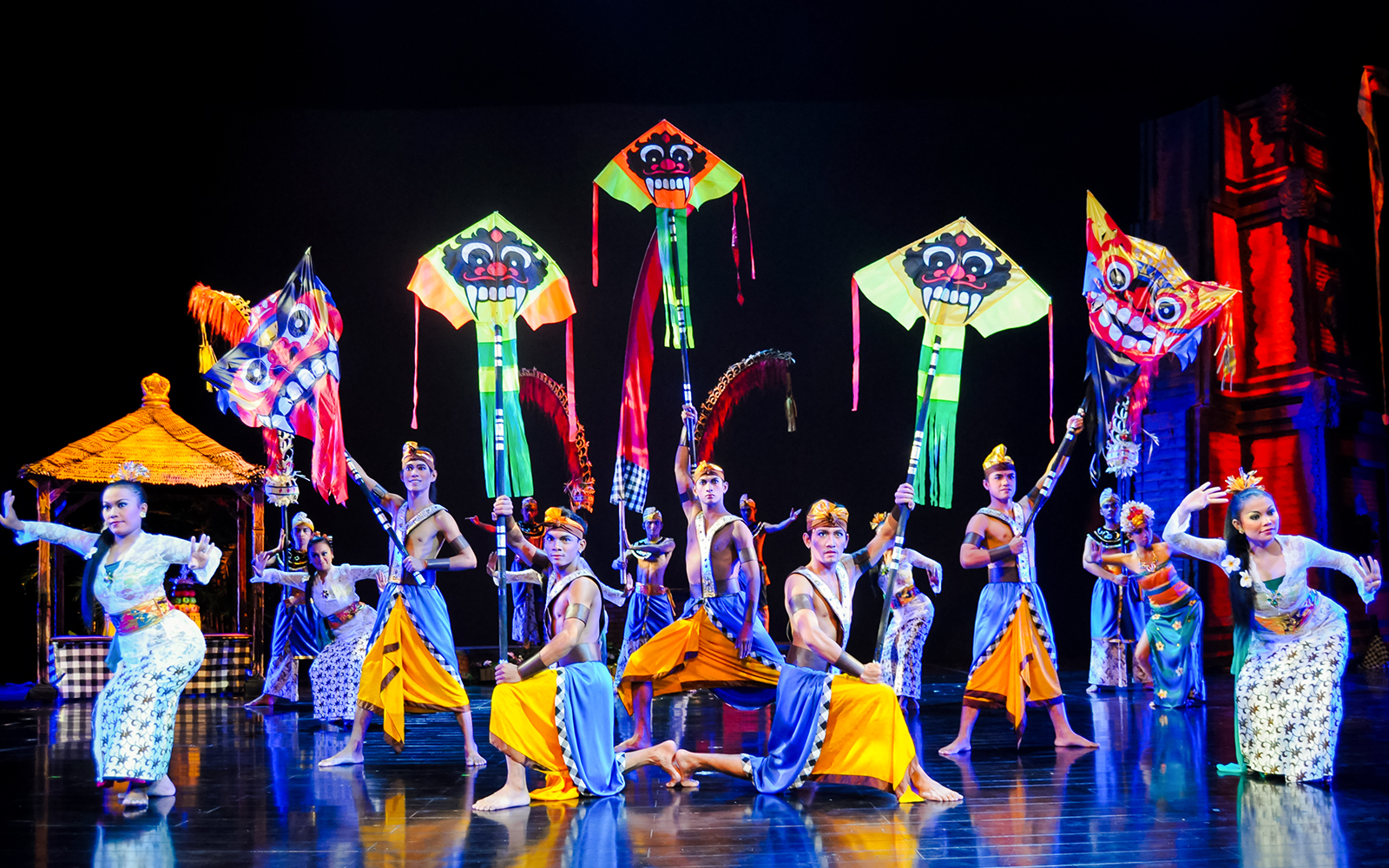 Performers at the Devdan Show in Bali with colorful kites above.