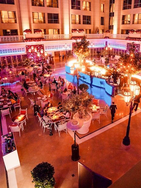 Dining area at Le Patio Restaurant, Dubai, with guests enjoying meals under ambient lighting.