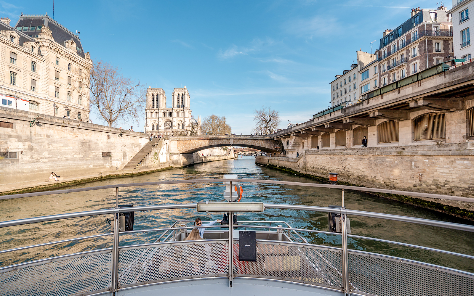 Seine River cruise view with Notre-Dame Cathedral and Parisian architecture.