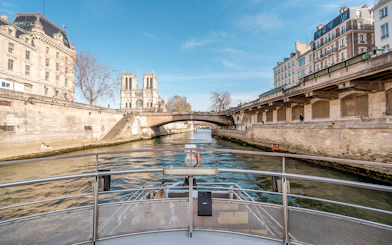 Seine River cruise view with Notre-Dame Cathedral and Parisian architecture.