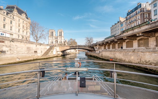 Seine River cruise view with Notre-Dame Cathedral and Parisian architecture.