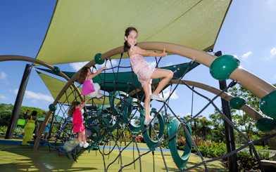 Children climbing a rope structure at Zoo Miami playground.