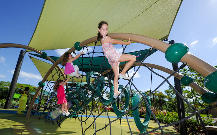 Children climbing a rope structure at Zoo Miami playground.