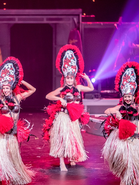 Dancers performing in traditional costumes at Rock-A-Hula Show in Honolulu.