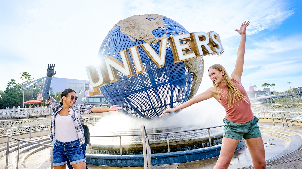 Guests posing in front of the Universal globe and fountain at Universal Studios, Orlando.
