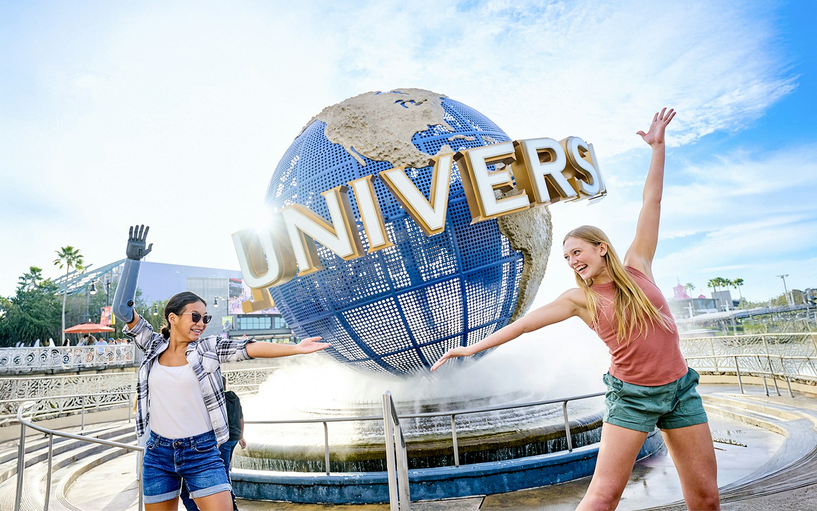Guests posing in front of the Universal globe and fountain at Universal Studios, Orlando.