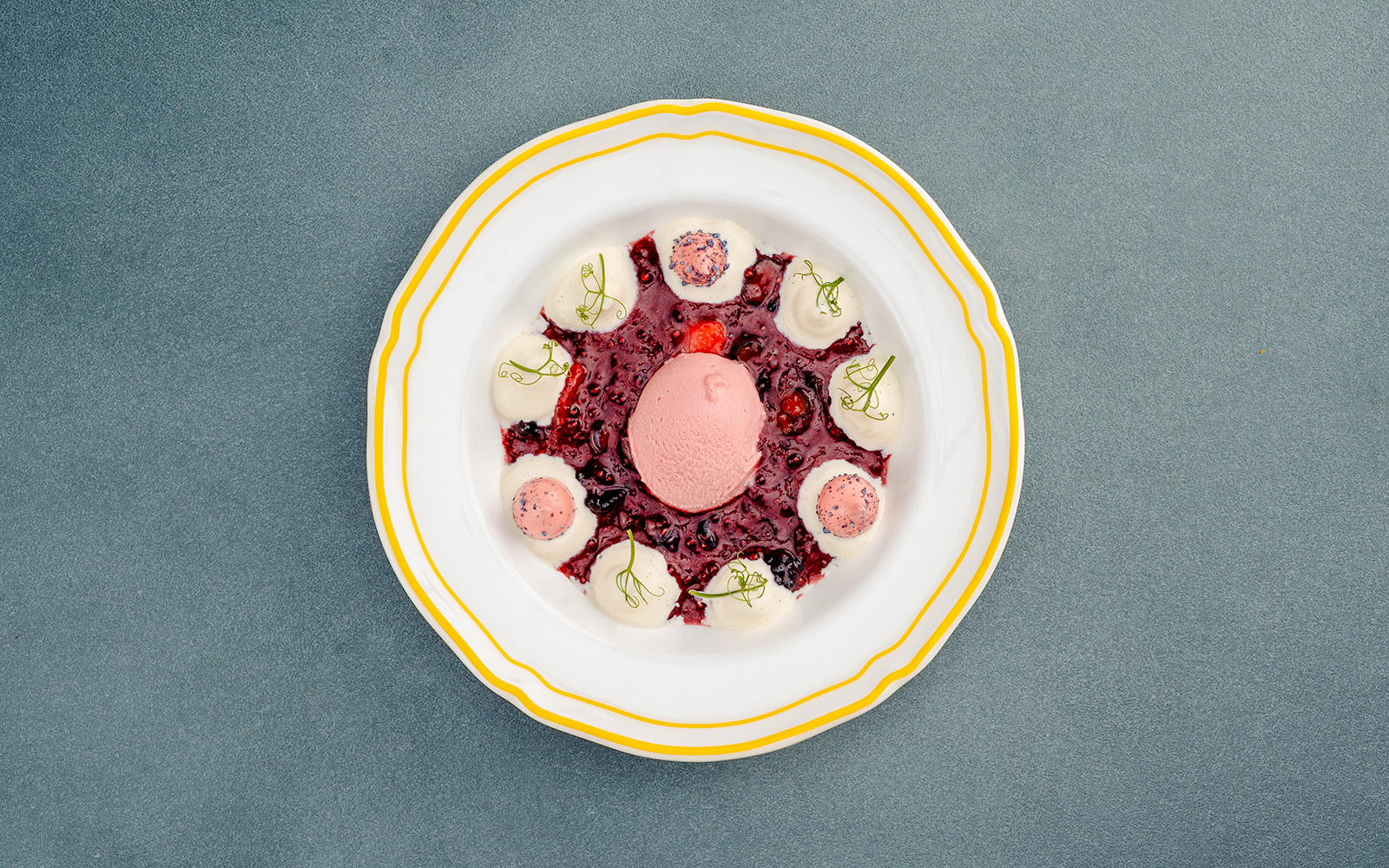 Berlin dessert with berry sauce and cream on a decorative plate.