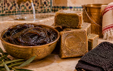 Traditional Moroccan soap and black soap paste in a Tangier hammam setting.
