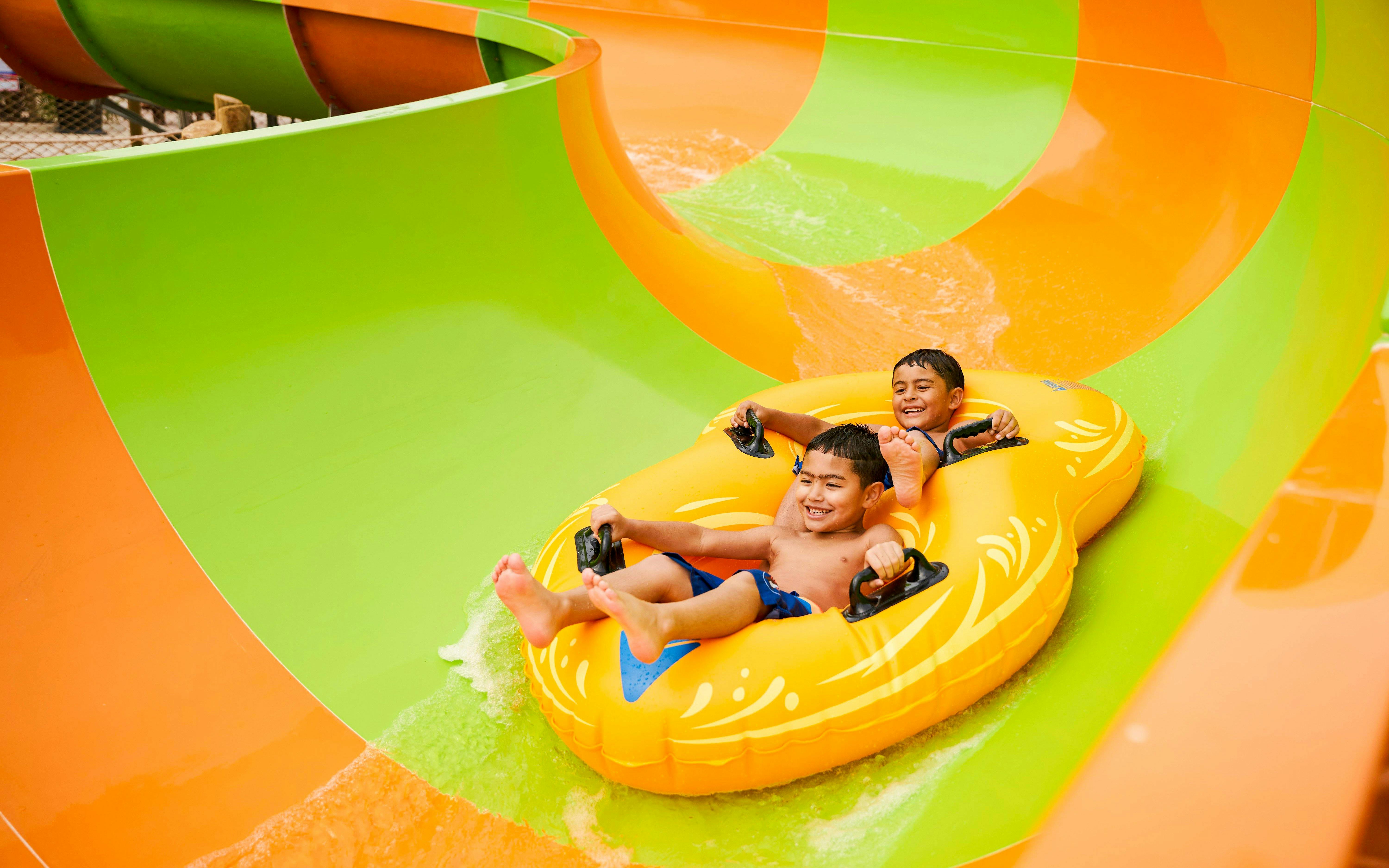 Children enjoying a water slide at Hurricane Harbor Arlington.