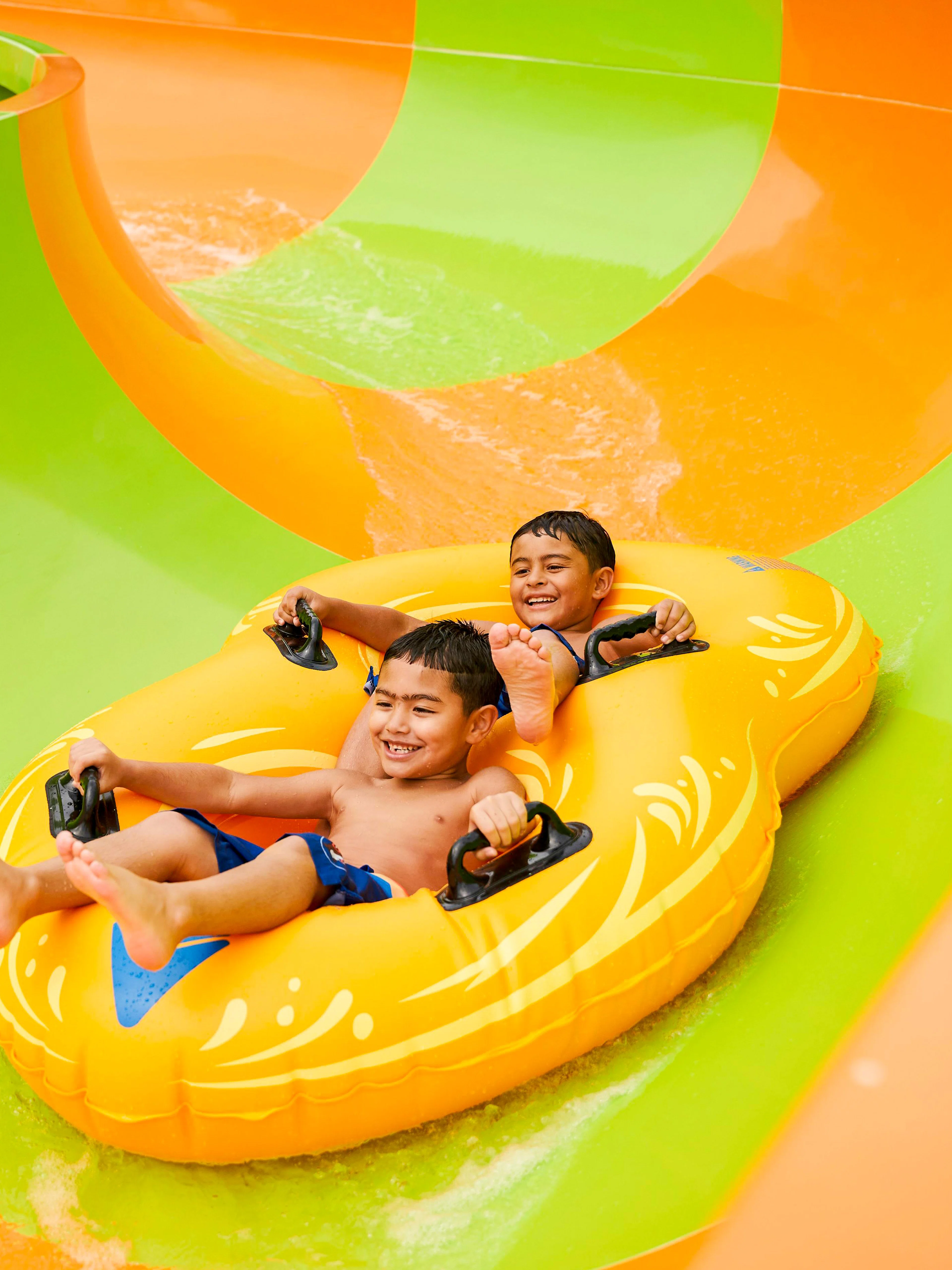 Children enjoying a water slide at Hurricane Harbor Arlington.