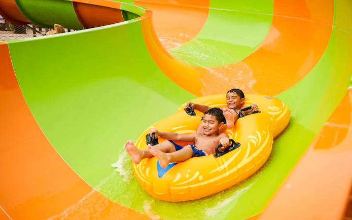 Children enjoying a water slide at Hurricane Harbor Arlington.