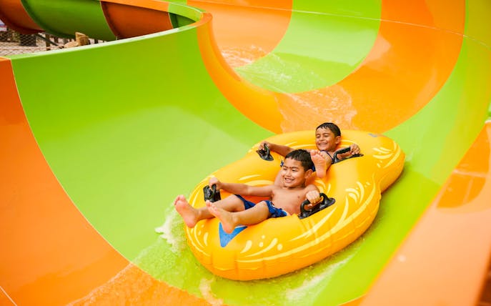 Children enjoying a water slide at Hurricane Harbor Arlington.