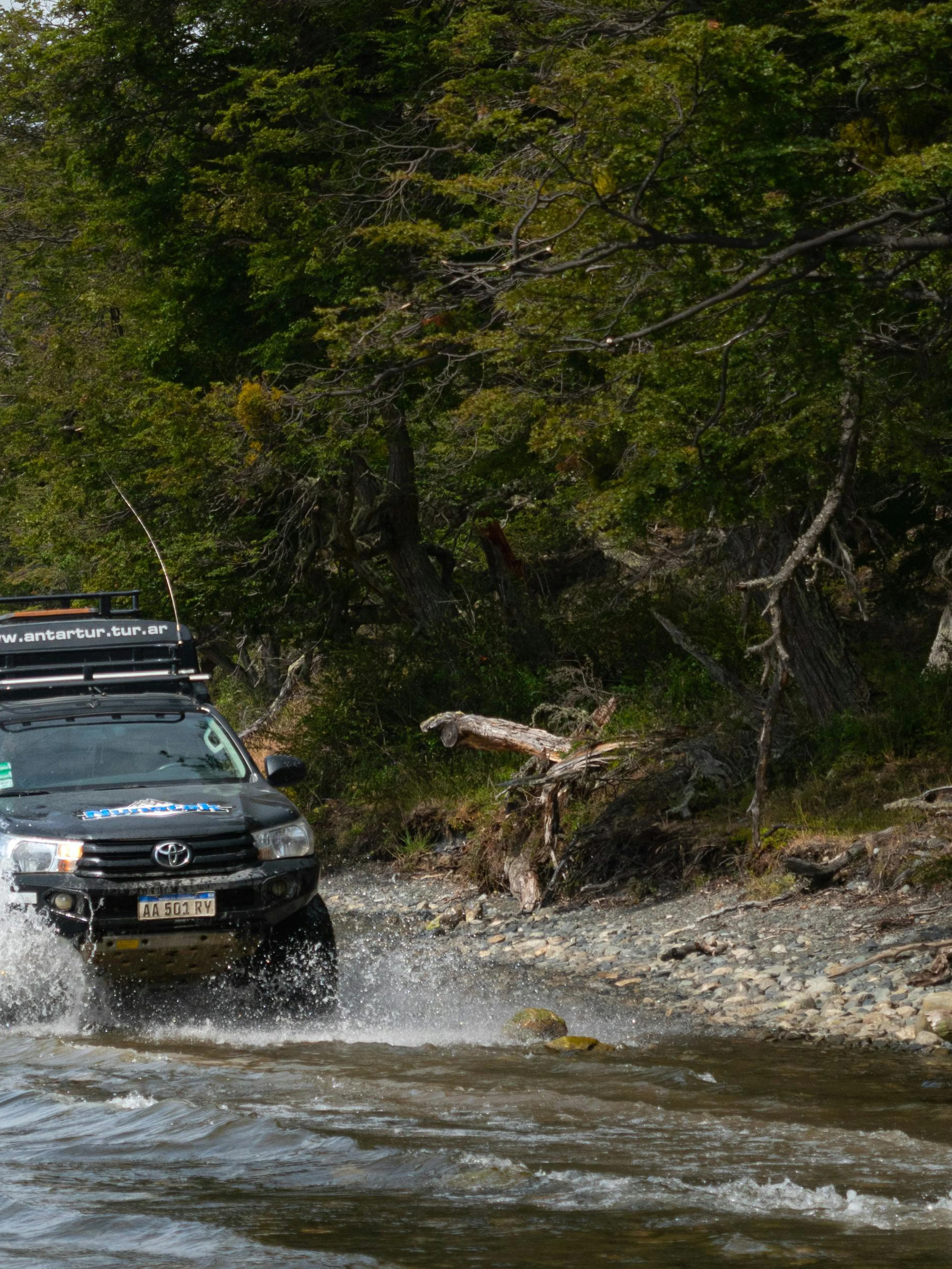 4x4 vehicle driving through water on off-road tour near Lakes Escondido and Fagnano.