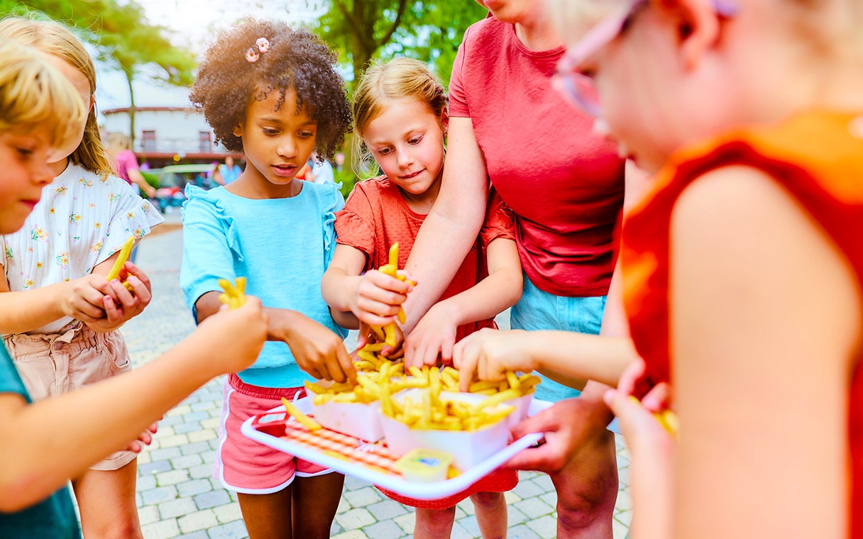 Children enjoying fries at Bobbejaanland theme park.