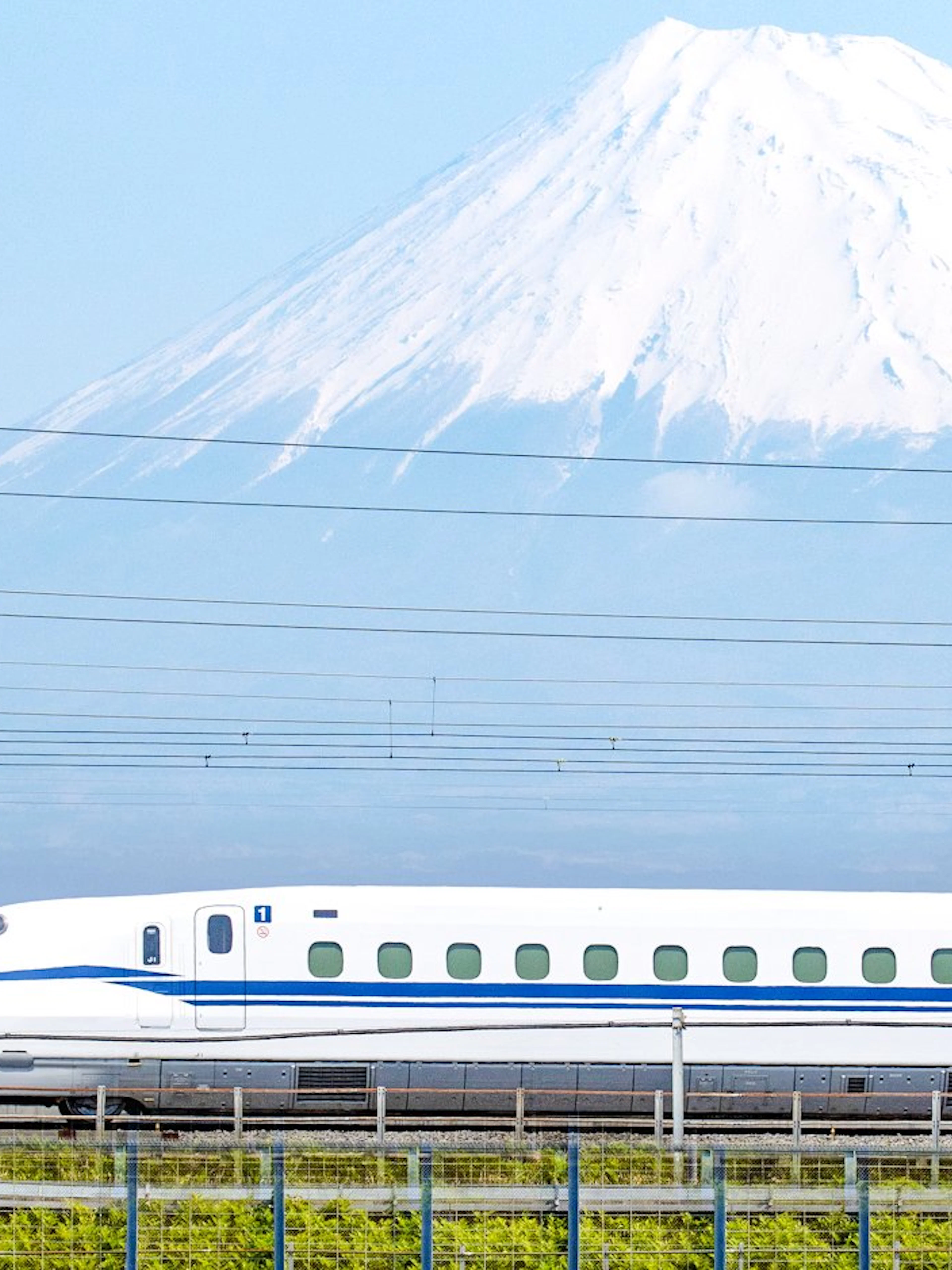 Shinkansen train passing in front of Mount Fuji, Japan.